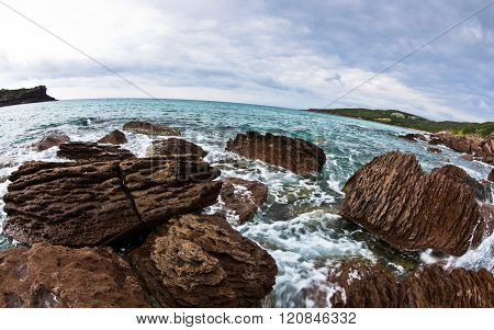 Sea rocks and waves at beach in San Pietro island, Sardinia