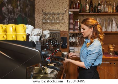 equipment, coffee shop, people and technology concept - barista woman making coffee by machine at cafe bar or restaurant kitchen