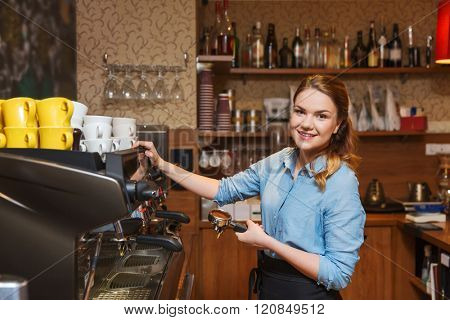 equipment, coffee shop, people and technology concept - barista woman making coffee by machine at cafe bar or restaurant kitchen
