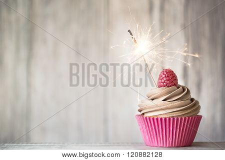 Cupcake decorated with chocolate buttercream and a sparkler
