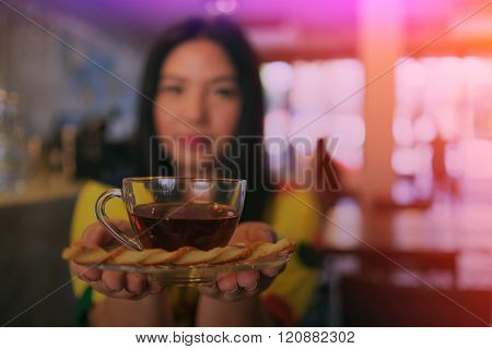 Woman In Colorful Dress Is Drinking And Sipping Hot Tea In Coffee Shop, Blurry Woman And Filtered Ef