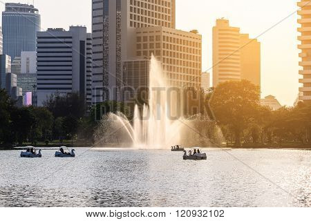 Beautiful fountain in urban lake with closeup building background.