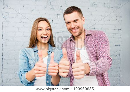 Attractive Cheerful Young Lovers Showing Thumbs Up