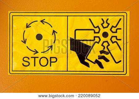 Warning sign on agricultural machinery. Do not touch the moving parts of the machine until they are completely stopped.