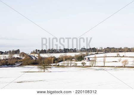 An image of a farm cottage situated in a snow covered landscape shot near Kibworth Harcourt, Leicestershire, England, UK