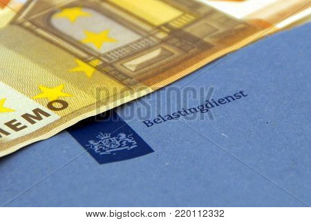 Amsterdam, The Netherlands - December 30, 2017: Blue enveloppe of the dutch tax department ('Belastingdienst') with a 50 Euro note.