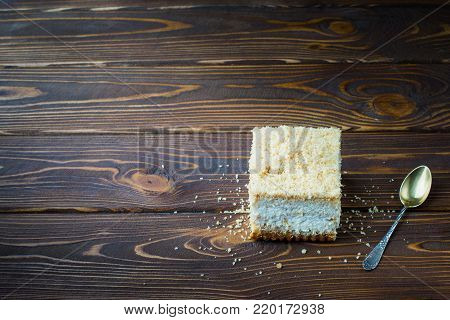 Delicious Piece Of Cake With A Spoon On A Wooden Table. Crumbs On A Wooden Table With A Cake.