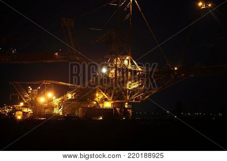 bucket wheel excavator digging for brown coal night view Poland extractive industry