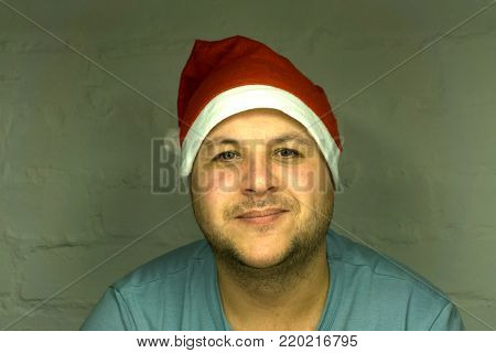 Portrait of a happy smiling man in a Suite and red cap like Santa keeps the gifts to a Young Santa Claus in a real house or car for.