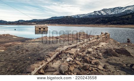 Abandoned And Partially Submerged Stone Building In Lake In Corsica