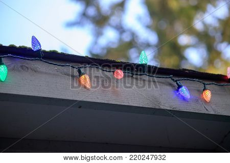 christmas lights on a string hang outside in the evening with copy space.