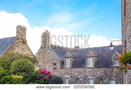 Locronan, France, view of the traditional medieval houses in Charettes street with flowers in the foreground