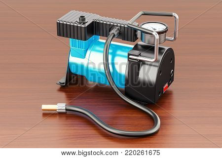 Car portable electric air compressor on the wooden table. 3D rendering