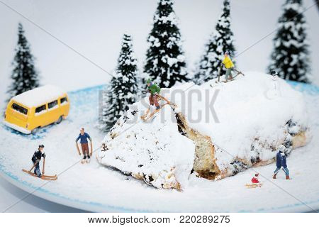 macro of miniature skiers on a plate with cake