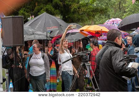 Adelaide, AU - November 15, 2017: Supporters wait patiently in the rain at Hindmarsh Square to hear the result of the Australian Postal Survey on Marriage Equality.