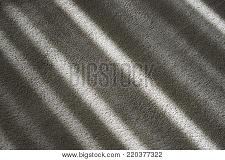 Cast diagonal shadows creates pattern on beige carpet.