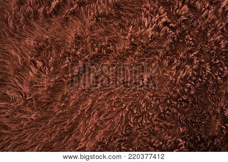 Soft red blanket creates texture with light on the long strands of material.