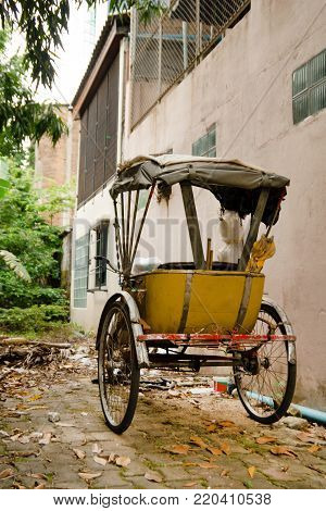 Traditional Thai transport - old yellow trishaw on a street. Chiang Mai, Thailand.