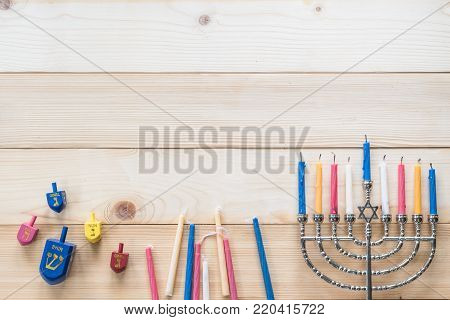 Hanukkah/ Chanukah Jewish holiday background with menorah (Judaism candelabra) burned candles and Dreidel spin game toy with 4 Hebrew letters meaning 