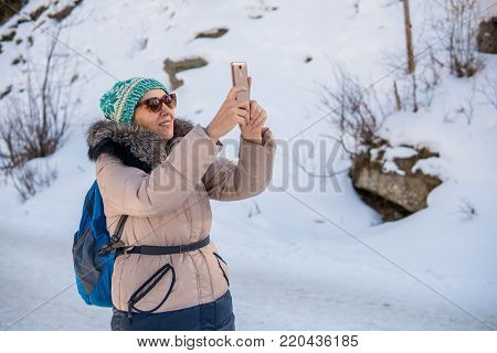 Woman 50 Years Old Taking Photo In The Mountains In Winter, Almaty, Kazakhstan