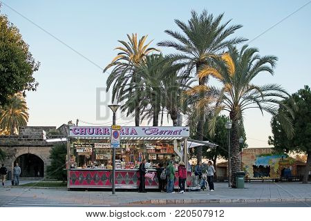PALMA DE MALLORCA, BALEARIC ISLANDS, SPAIN - DECEMBER 5, 2017: Churreria Bernat with people at sunset on December 5, 2017 in Palma de Mallorca, Balearic islands, Spain.
