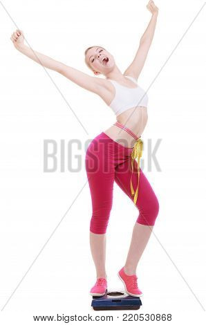 Fit fitness woman with measure tape happy blonde girl on weight scale celebrating weightloss progress after diet, she lost some weight. Healthy lifestyles concept