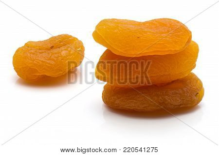 Three dried apricots in pile and one isolated on white background