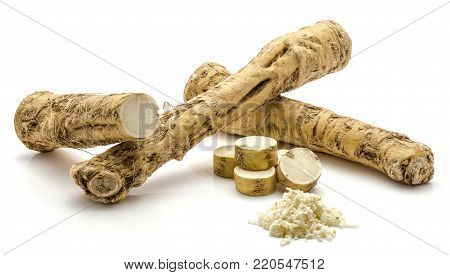 Two whole, one half and freshly grated mash of horseradish root, isolated on white background, sliced circles