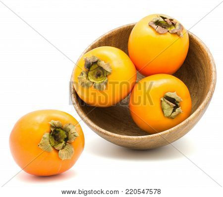 Persimmon Sharon in a wooden bowl isolated on white background