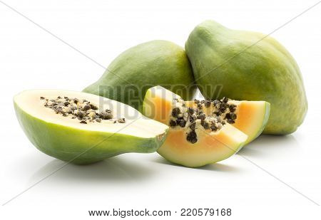 Green papaya (pawpaw, papaw) two whole one half and two slices with seeds isolated on white background