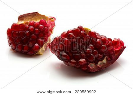 Pomegranate parts with grains isolated on white background split open