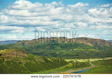 Travel to Iceland. road and river in a bright sunny mountain landscape. Vatna volcano covered with snow and ice on tne background.