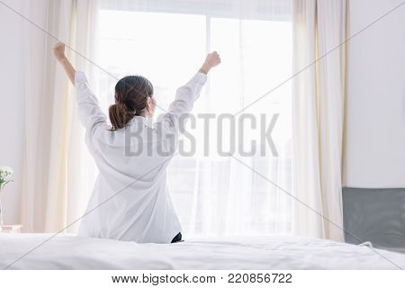 Happy Woman Stretching On Bed After Waking Up In The Early Morning At Window Side. Have A Good Day.