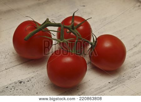 red tomatoes an annual plant on a light background with autumn colorful leaves