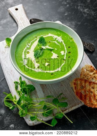 Green sweet pea and mint soup with cream and olive oil drizzle served with grilled ciabatta toasts.