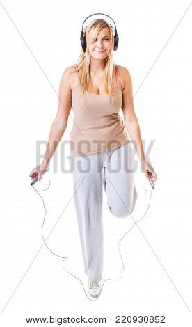 young sporty girl plus size doing exercise with jump rope while listening music. Weight loss concept. Fitness woman isolated on white