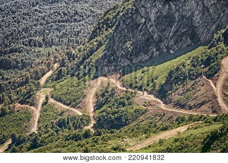 Mountain landscape  steep mountains, covered with forests, form a deep gorge, on the slope of a mountain winding road with steep turns - a mountain serpentine.