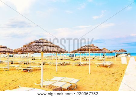 Beach chairs and umbrellas in Rimini, Italy during summer day with blue sky. Summer vacation and relax concept