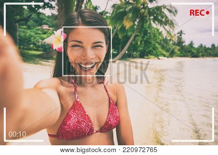 Selfie photo on beach Asian woman taking video recording on travel holiday in luxury Bora Bora island Tahiti vacation. Girl tourist vlogging online while traveling for social media.