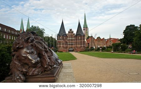 Scenic View Of Holsten Gate Or Holstentor And Statue Of A Lion In Old Town, Beautiful Architecture, 