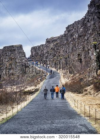 19 April 2018: Thingvellir National Park, Iceland - Visitors Walking In The Almannagja Canyon Which 