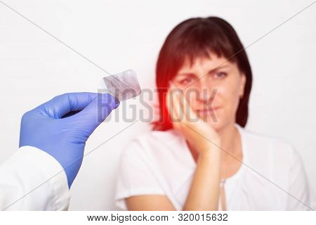 A Dentist Doctor Holds An X-ray Of A Patient With Pulpitis Of A Tooth Against A Background Of A Girl