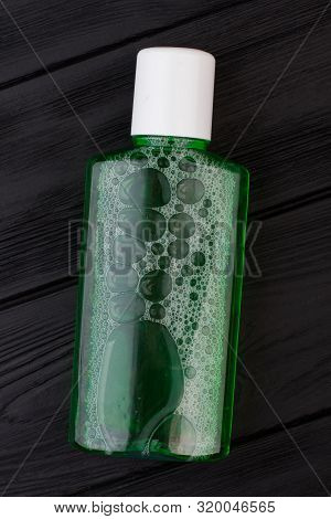 Rinser For Teeth On Black Background. Mouthwash Plastic Bottle. Dental Health Concept.