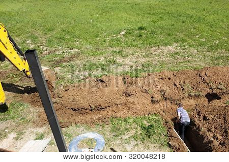 The Excavator Digs A Trench To Lay The Electric Cable.