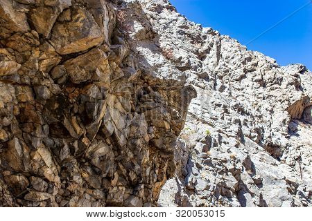 Rocks In The Mountains Against The Blue Sky.