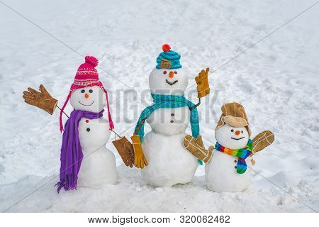 Cute Little Snowman Group Outdoor. Merry Christmas And Happy New Year. Cute Snowmen Standing In Wint