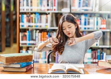 Asian Young Student In Casual Suit Reading And Doing Stretch Oneself In Library Of University Or Col
