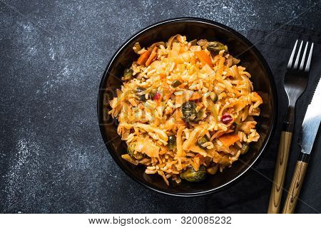 Cabbage Stew With Rice And Vegetables. Meatless Vegan Dish. Top View On Black Stone Table.