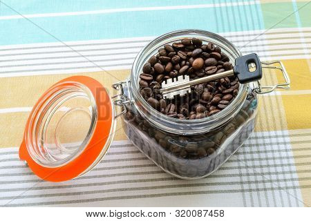 Large Key In A Clip Top Glass Jar With Coffee Beans On A Tablecloth. Can For Bulk Food Products As A