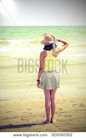 Little Girl With Straw Hat Also Called Boater In Summer And The Sea On Background With Old Toned Eff